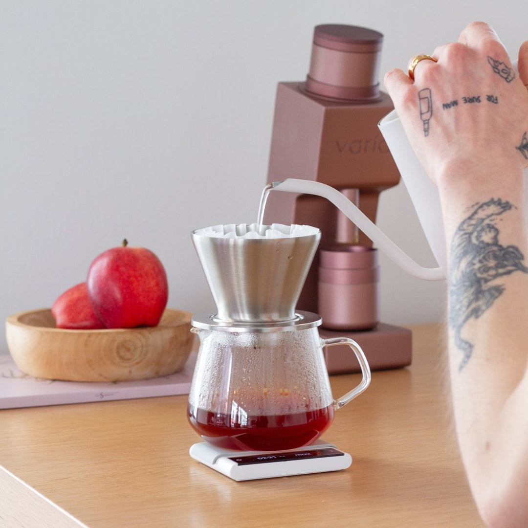 Preparazione di un pour-over accanto al Varia VS4 rosa